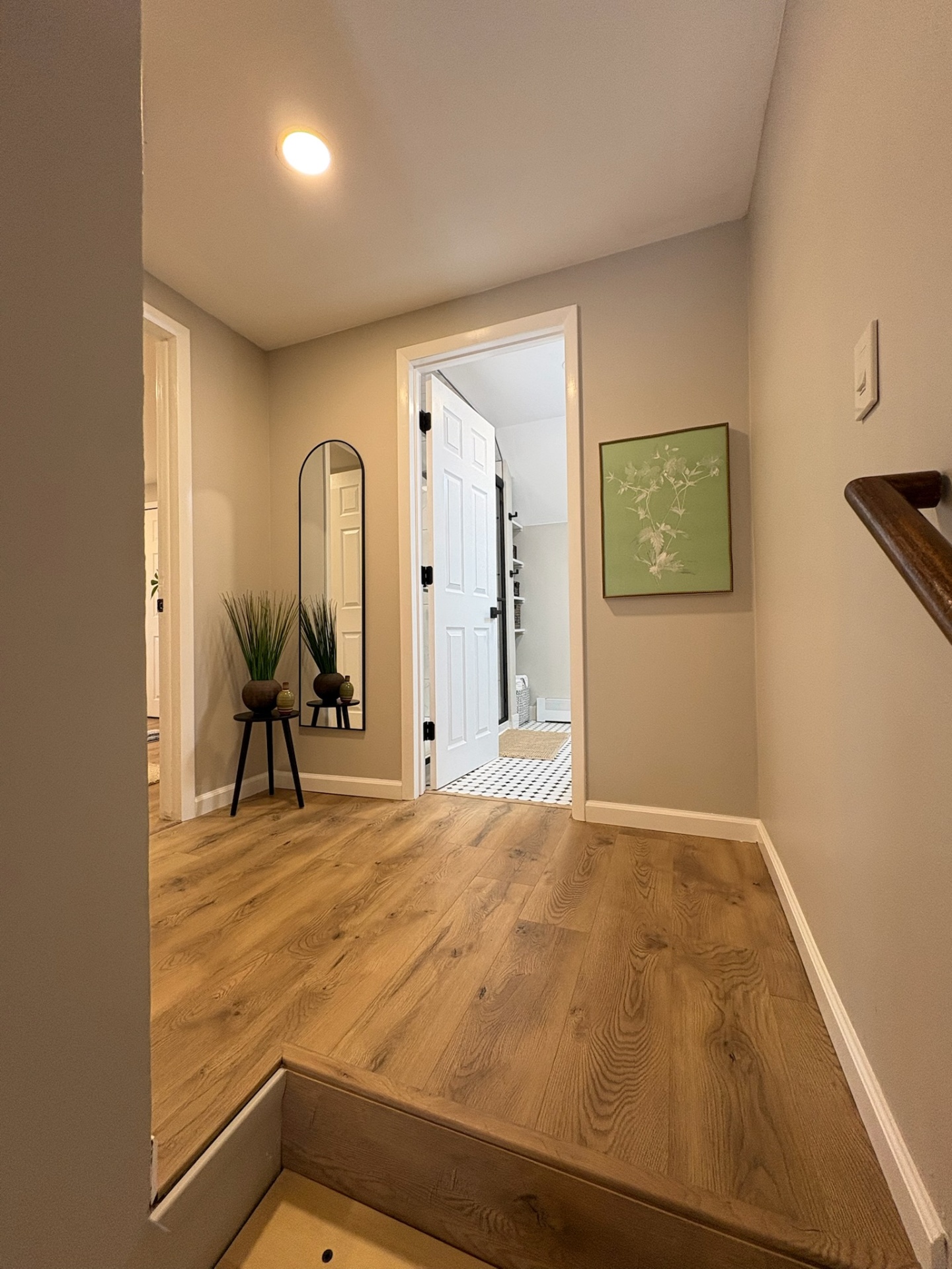 Hallway with mirror and entry to bathroom