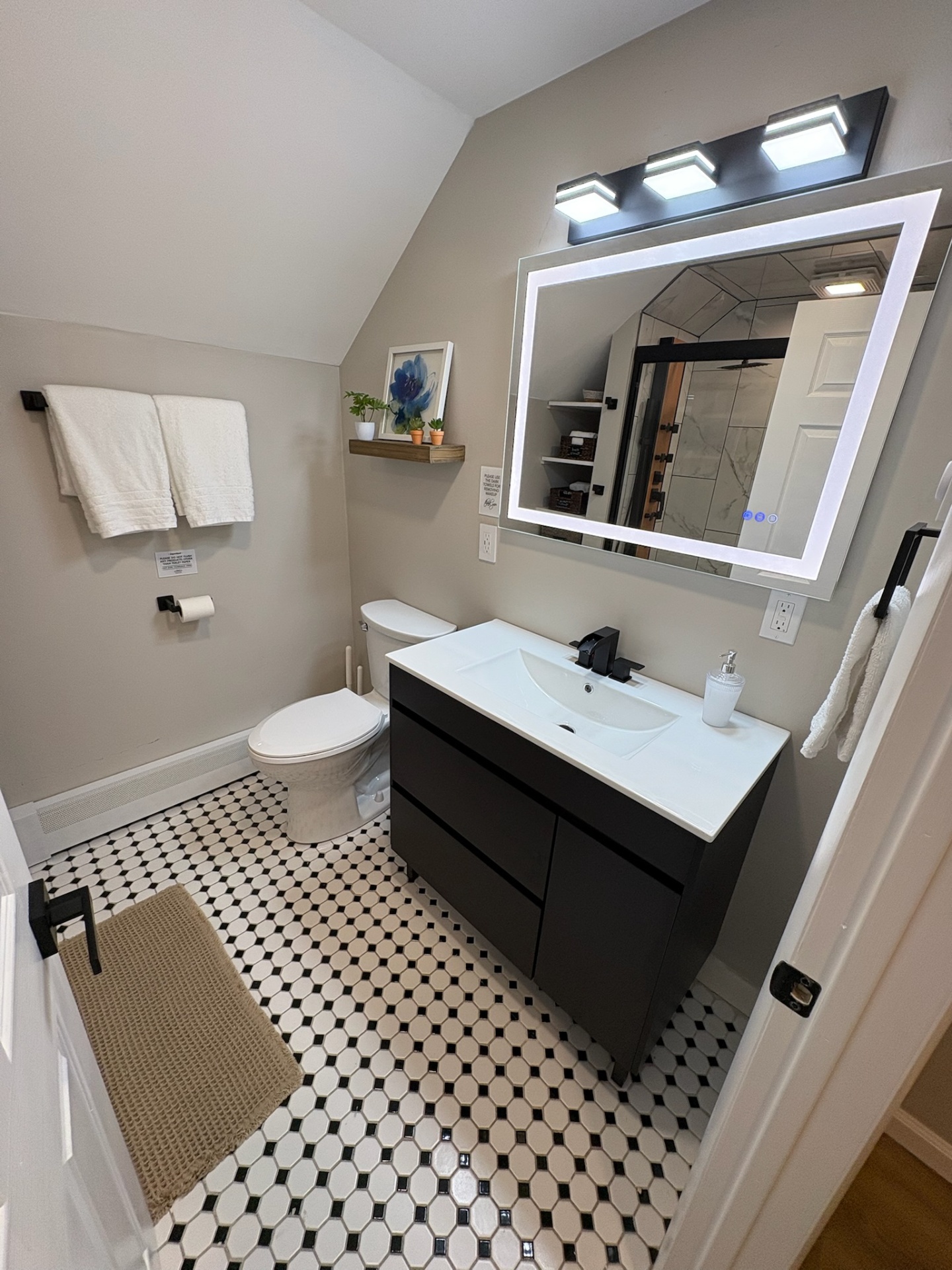 Bathroom with lighted mirror and vanity